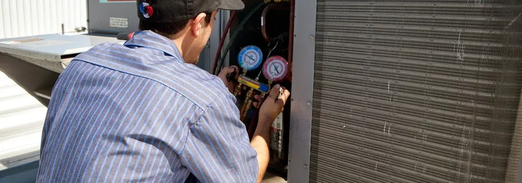 HVAC technician servicing a condenser unit in Kannapolis