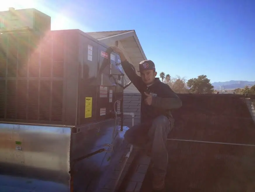 HVAC technician performing AC Tune-Up on a rooftop unit in Kannapolis